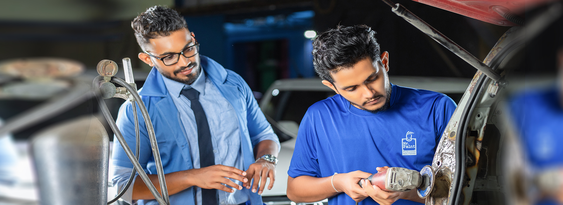 An employee doing tinkering on a car at Mr. Paint Auto