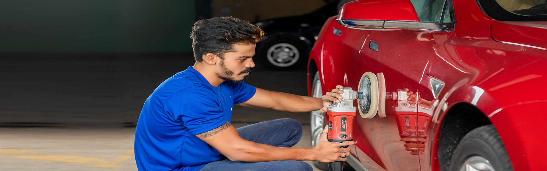 An employee polishing a car at Mr. Paint Auto