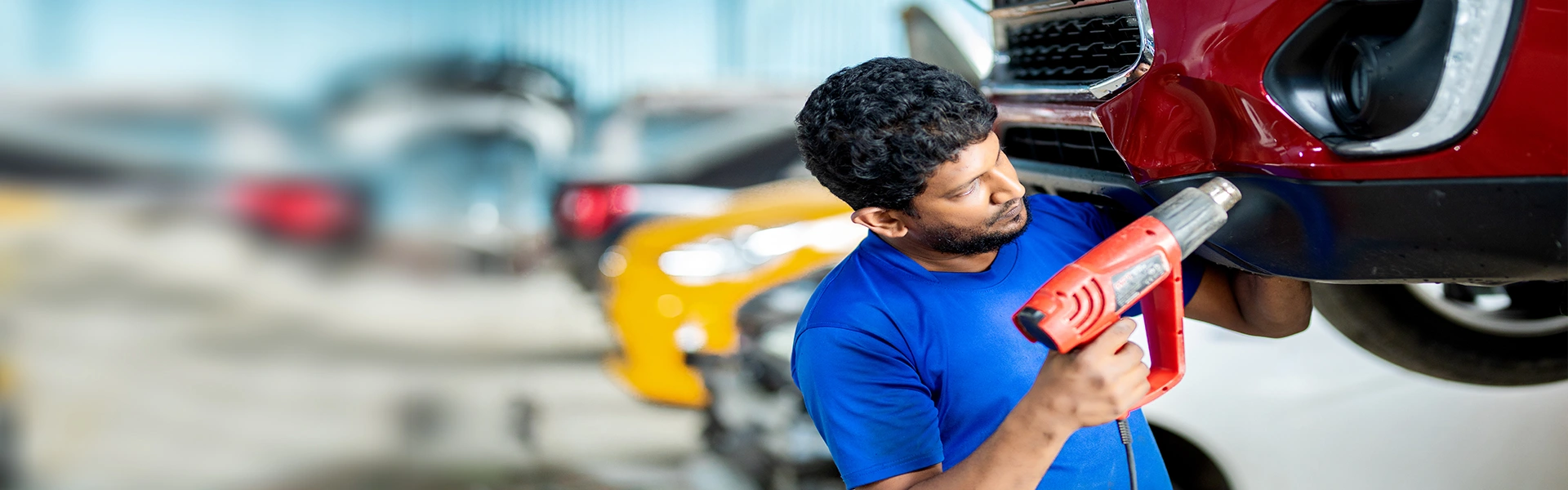 A Mr. Paint Auto employee working on a plastic welding of a car