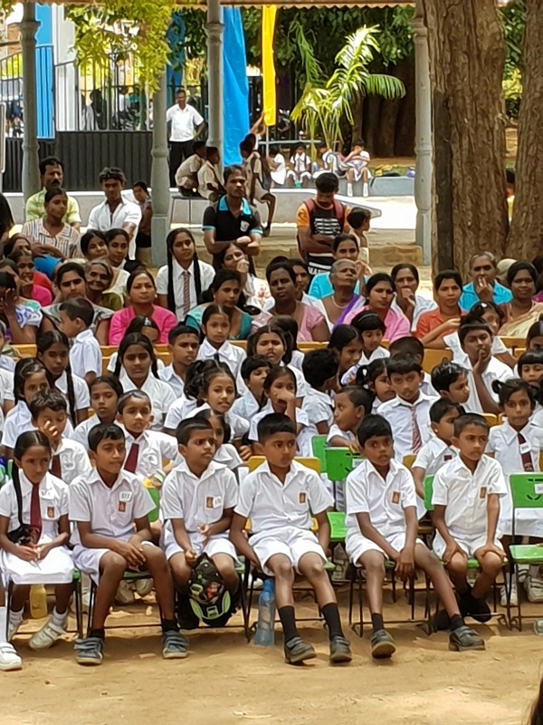 School kids and parents sitting outside