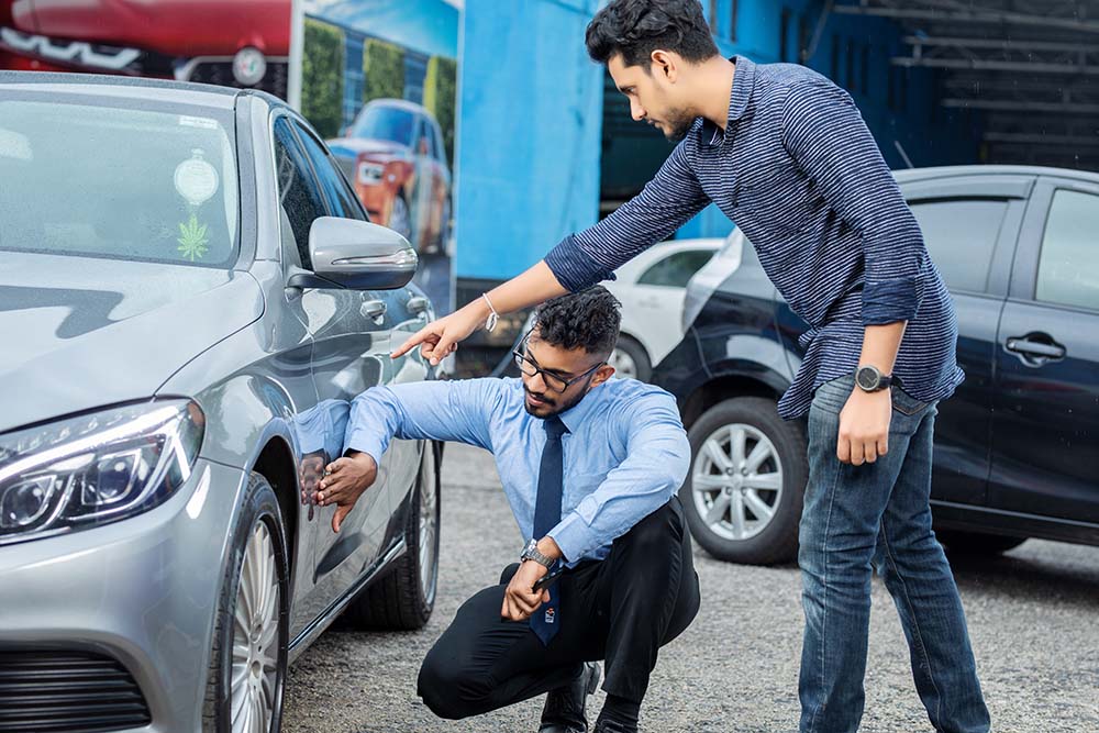 A client and an employee cheking out a car at Mr. Paint Auto
