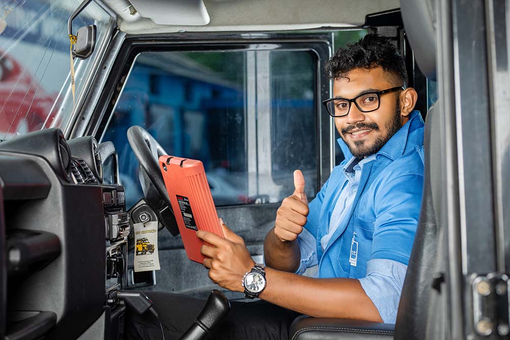 An employee of Mr. Paint Auto posing inside a car