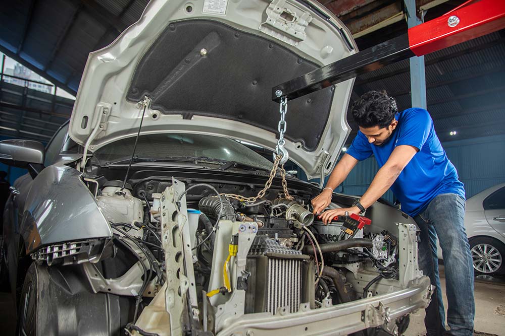 A man fixing a car at Mr. Paint Auto