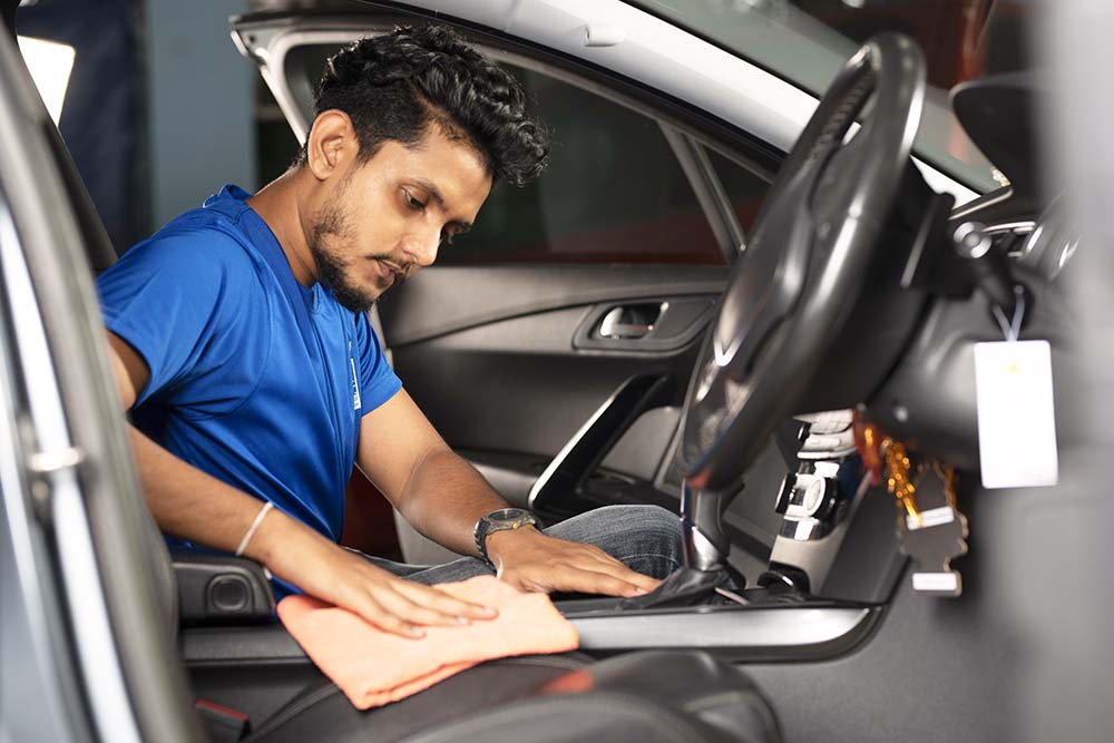 Employee of Mr. Paint Auto cleaning inside of a car