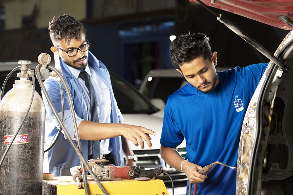 A man in a vehicle repair process at Mr. Paint Auto