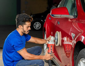 An employee polishing a car at Mr. Paint Auto