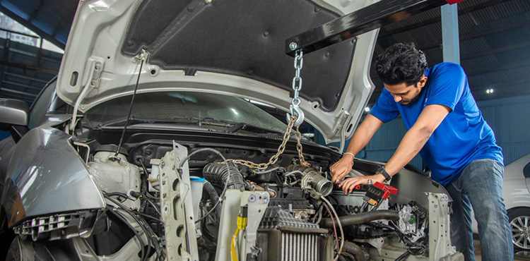 A man fixing a car at Mr. Paint Auto