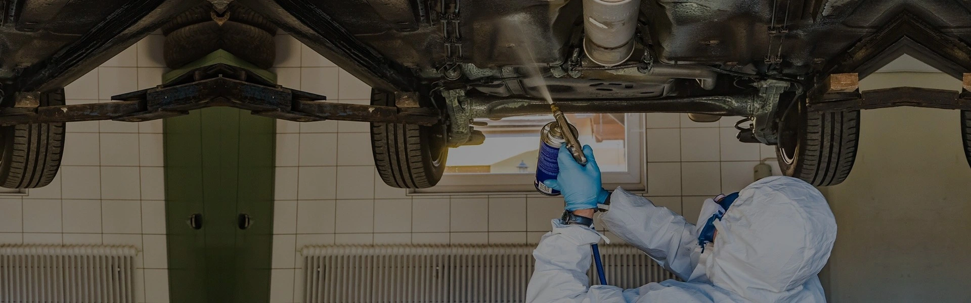 A man undercoating a car at Mr. Paint Auto