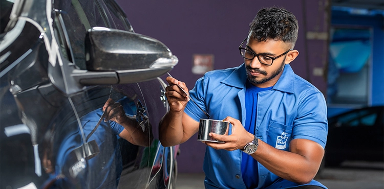 A worker of Mr. Paint Auto in the proccess of auto painting